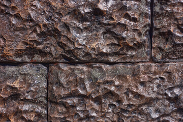 Brown lacquered stone masonry with jointing.