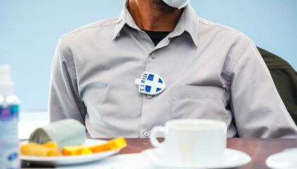 Jakarta 21th April 2021 Asian man using ea mask badge clip on his daily activity in selective focus...