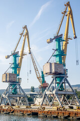 Fototapeta na wymiar Massive harbor cranes in port. Industrial scene
