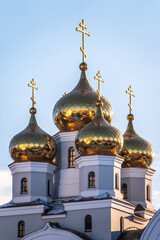 Fototapeta na wymiar The golden domes of the Christian church in sunset light.