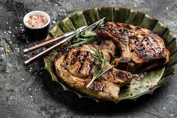 two pieces of of grilled pork with herbs on metal tray. Restaurant menu, dieting, cookbook recipe