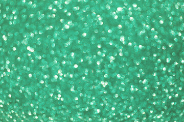 Defocused Christmas green background. Holiday abstract glitter defocused background with blinking bokeh.Holiday glowing backdrop.Banner.