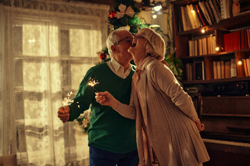 Fototapeta premium Sparkly Christmas at home for loving senior couple
