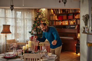 Middle aged man showing to his friends decorated home via cellphone