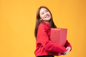 Attractive Asian woman holding gift box in christmas, new year, valentine day, birthday celebration concept. Portrait of smiling happy pretty girl hold gift box isolated on white with copy space.