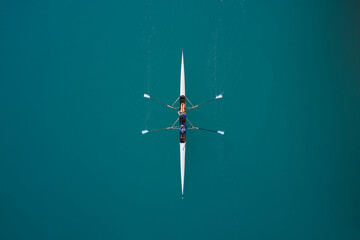 White rowing boat in motion with two women, top view. Top view of the rowing race. Aerial view of...