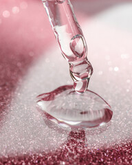 Cosmetic pipette with a pink on dark background.