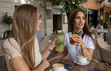 Girlfriends drinking cocktails in the outdoor cafe