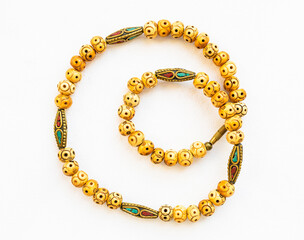 vintage necklace from carved bone and inlaid brass beads on white paper