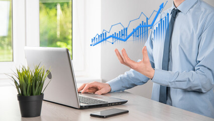 Business man holding tablet and showing holographic graphs and stock market statistics gain profits. Concept of growth planning and business strategy. Display of good economy form digital screen.