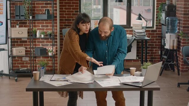 Furious man throwing chart papers in air after argument with woman in startup office. Colleagues in conflict having quarrel and dispute while working on business project. Workmates fighting