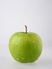 A perfect fresh green apple isolated on a white background in full depth of field with an edged trajectory.