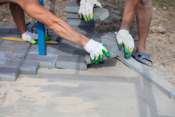A worker lays paving slabs