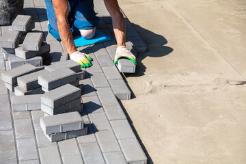 A worker lays paving slabs