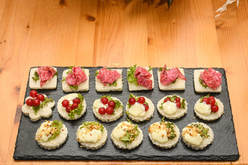 Assorted Fresh Canapés Appetizers On A Wooden Table
