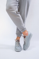 Men's sneakers on a very gray day of natural leather, men's legs shoes in gray leather shoes