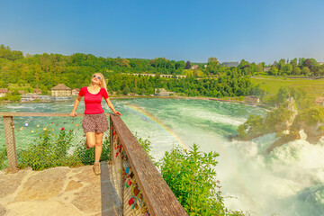 Girl with rainbow. Aerial view of Swiss waterfall Rhine Falls in Switzerland. The most powerful and...