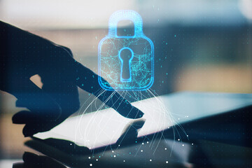 Close up of hand using tablet with glowing blue padlock hud on blurry background. Safety, web security and future concept. Double exposure.