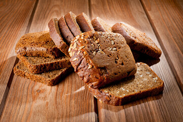 Bread made from natural products, on live sourdough, without baker's yeast, cut into skibbles on a wooden table surface.