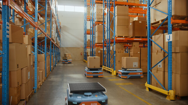 Future Technology 3D Concept: Automated Modern Retail Warehouse AGV Robots Transporting Cardboard Boxes in Distribution Logistics Center. Automated Guided Vehicles Delivering Goods, Products, Packages