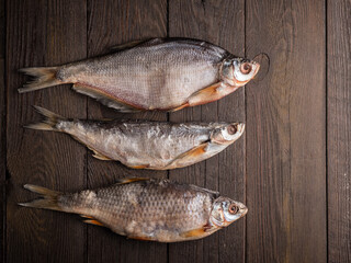 Dried  fish stockfish on a brown wooden table. Top view with space for text