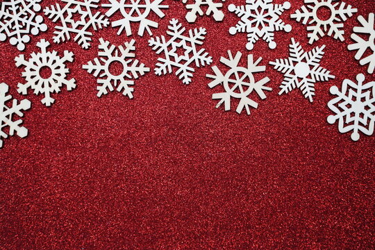 wooden snowflake border frame on red glitter background