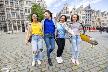 Multiracial group of young attractive women hugging, smilinh and walking in the city center. urban lifestyle, fun. High quality photo