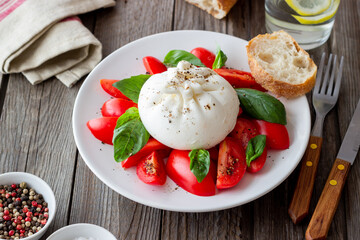Italian burrata cheese with tomatoes and basil. Salad. Healthy eating. Vegetarian food.