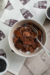 Mini pancakes with milk and seeds in a light plate. Breakfast on the table with tablecloth. Coffee, pancake cereals, berries. Flat lay.