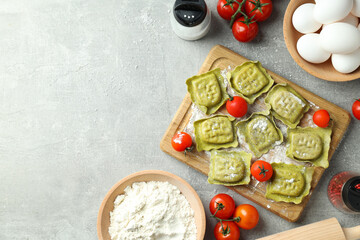 Concept of cooking ravioli on gray textured background