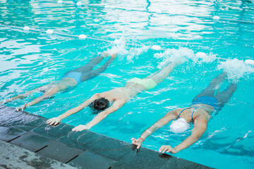 girl and boy doing swimming exercise at the pool