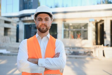 Industrial theme: constructor standing at a site area.