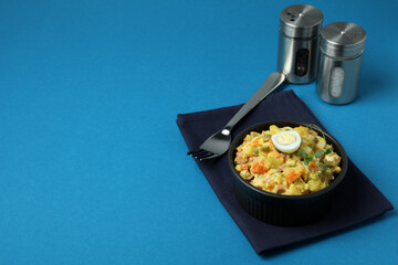 Concept of tasty food with Olivier salad on blue background