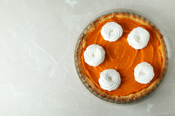 Pumpkin pie in round dish on gray background