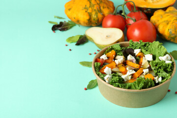 Concept of healthy food with pumpkin salad on mint background