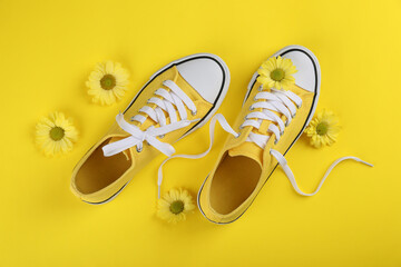 Yellow sneakers with flowers on yellow background
