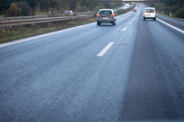 Fototapeta na wymiar low trafflic on german highway, red backlights, cars, motion blur, focus on asphalt in the front