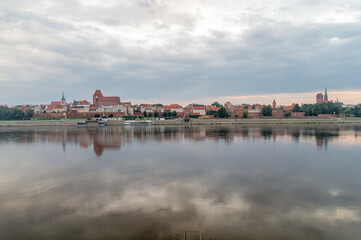 Fototapeta premium Morning view of panoramic view on Old town of Torun city walls and reflection in Vistula river.