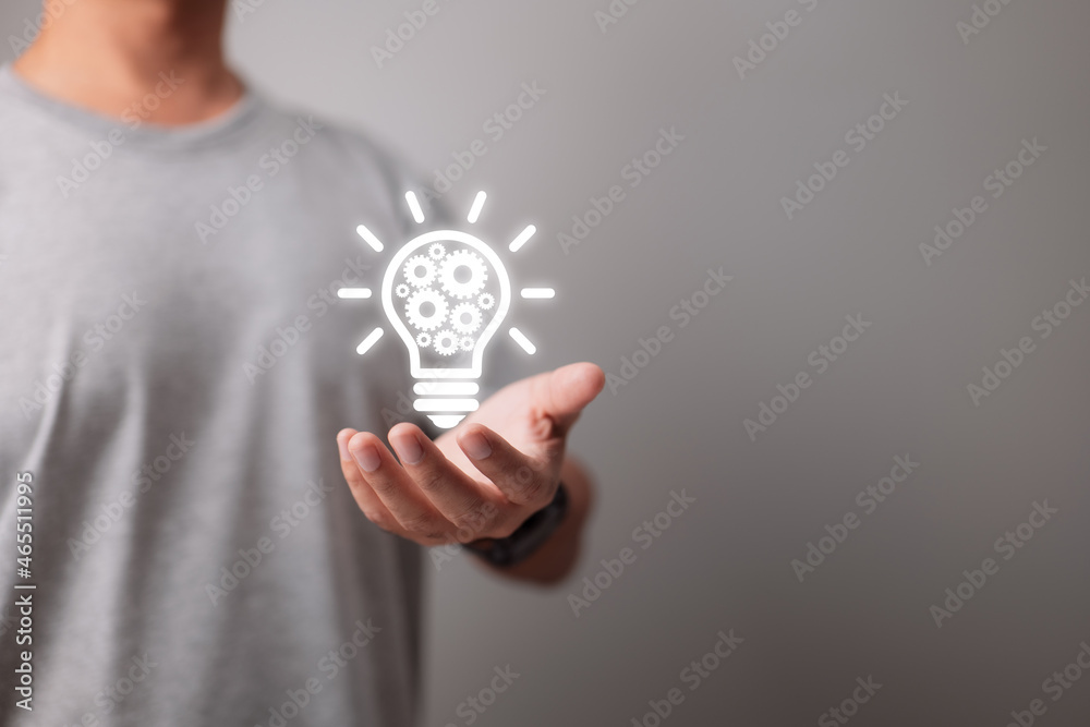 Poster on hand is a business concept bulb gear web engineering button icon.