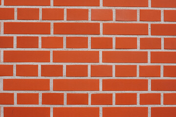 Textured red brick wall background or backdrop, rectangular red terracotta bricks laid out as pattern, architectural structure for old rough building