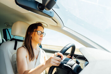 beautiful young middle age woman doing driving concentrated with glasses. with a serious face