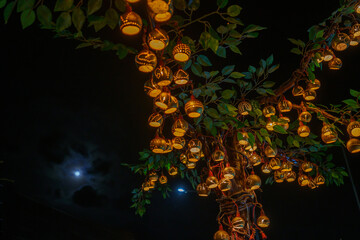 bokeh of Beautiful handmade lantern lamp made from (Strychnos nux-blanda A.W. Hill), fruits. On the trees at night of a traditional Thai festival celebrates. Event for The End of Buddh