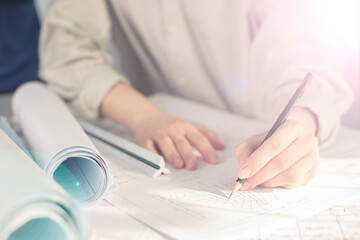 Architect working on blueprint. Architects workplace - architectural project, blueprints, ruler, calculator, laptop and divider compass. Construction concept. Blue print is fake only for stock photo.