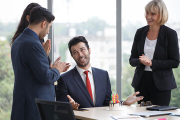 Group of business people celebrating birthday with cake to colleague in office. worker team