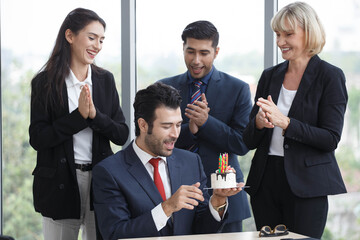 Group of business people celebrating birthday with cake to colleague in office. worker team