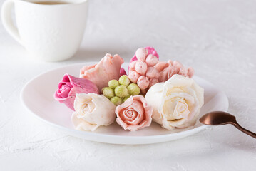 Delicious homemade flowers from marshmallows on a white plate.