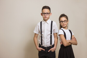 Portrait two schoolchildren with glasses over light background. School timing concept. Knowledge day. Space for text