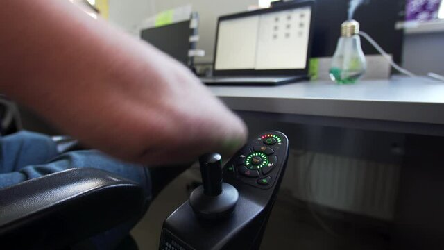 Close view of a wheelchair joypad controlled by man with amputated two stump hands and legs. A panel of a electronic wheelchair