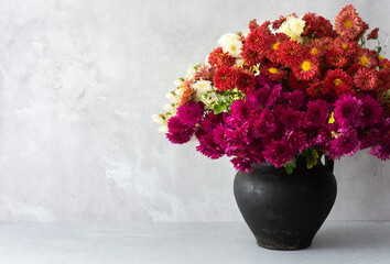 Beautiful bouquet of autumn multi-colored chrysanthemum flowers in a vase on the table, part of the fall home interior