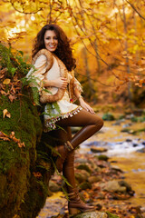 Autumn portrait with a beautiful woman in different positions near a mountain river.